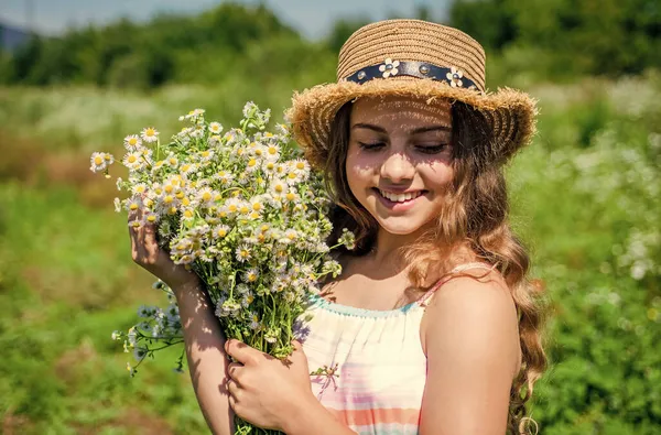 A beleza está a levar tempo para ser mimada. Menina feliz sorriso com camomila monte. Beleza olhar de criança pequena. Cuidado da pele natural e cuidados com o cabelo. Salão de cabeleireiro. Spa e resort. Férias — Fotografia de Stock