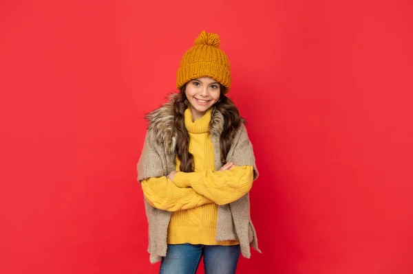 Wyrażać pozytywne emocje. Zimowa moda. szczęśliwy dzieciak z kręconymi włosami w kapeluszu skrzyżowane ręce. — Zdjęcie stockowe