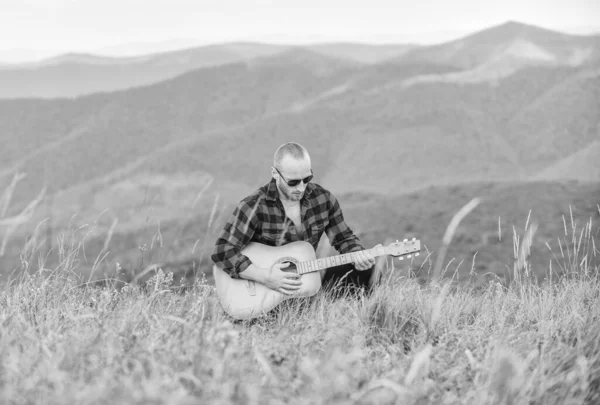 Acoustic music. Music for soul. Playing music. Sound of freedom. In unison with nature. Musician hiker find inspiration in mountains. Keep calm and play guitar. Man with guitar on top of mountain