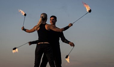 Dinamik ateş gösterisi. Seksi çift poi dansı yapıyor mavi gökyüzü. Poi performansı. Ateş dansı. Gece partisi. Tatil kutlaması. Sanat icra etmek. Eğlence ve eğlence