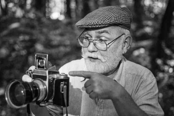 Vintage to mój styl. Wskazujący gest. Wskazuje i promuje. Starszy człowiek aparat fotograficzny Podróżująca koncepcja. Zdjęcie natury. Człowiek fotografujący naturę aparatem cyfrowym. Sukces dziennikarza — Zdjęcie stockowe