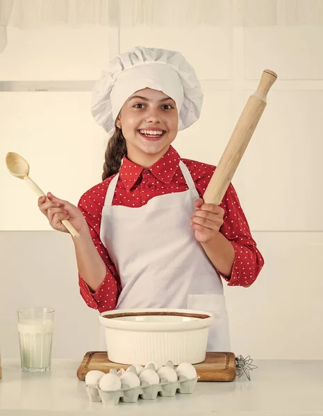 Pâtisserie maison. bonne enfance. heureux adolescent fille cuisson pâte. enfant en uniforme de chef. — Photo