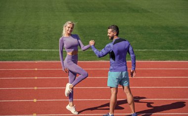 Sporcuların fitness partnerleri takımı spor yaptıktan sonra el sıkışarak ya da stadyumdaki koşu pistinde bilek güreşinde yarışarak, spor başarısını kutluyor.