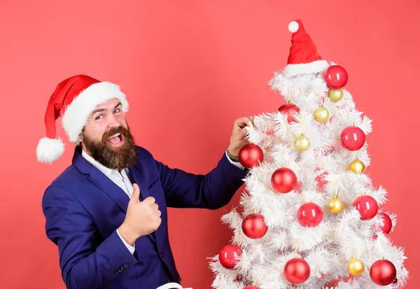 Obchodník zdobí novoroční stromek. muž slaví Vánoce. Veselé svátky. prodej zimní sezóny. Veselé Vánoce. vousatý muž Santa klobouk drží vánoční míč. magická tvořivost. bílé Vánoce — Stock fotografie