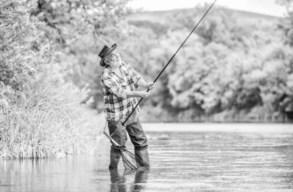 Fishing is fun. mature man fly fishing. man catching fish. summer weekend. Big game fishing. retired bearded fisher. Trout bait. fisherman with fishing rod. hobby and sport activity. pothunter — Stock Photo, Image