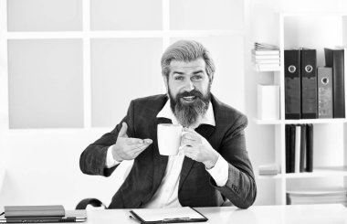 Saygıdeğer CEO. Yakışıklı patron ofiste oturup kahve içiyor. Sakallı hippi kıyafeti kahveyle rahatlıyor. İlham verici ve motive edici. Ofiste sabah kahvesi. Ofis hayatı. Güzel kahve.