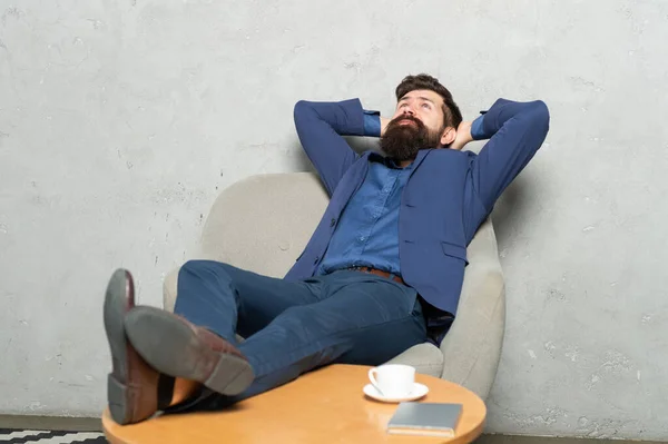 İyi dinlenmek iyi gelir. İş adamı koltuğuna oturur. Sakallı adam, ayağa kalkmadan rahatla. Dinlenme molası. İş sırasında dinlenme — Stok fotoğraf