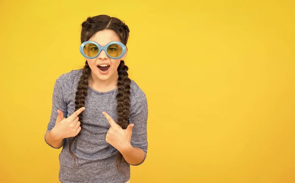 Щаслива дівчина-підліток з плетеним волоссям носити сонцезахисні окуляри на жовтому фоні, копіювати простір, вечірка весело — стокове фото