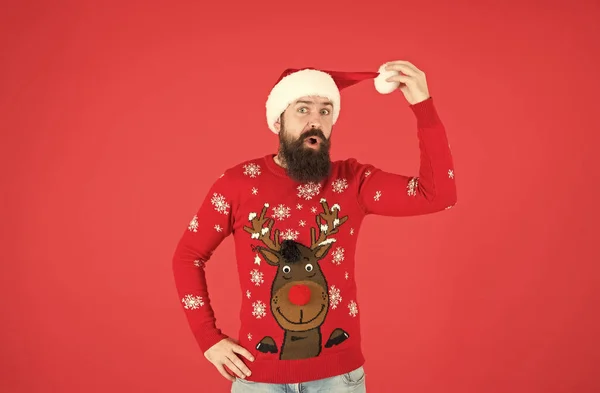 Überraschter bärtiger Kerl in warmem Strickpullover und Weihnachtsmann-Mütze feiert Winterfest der Weihnacht und freut sich über Weihnachtsgeschenke, Strickmode — Stockfoto