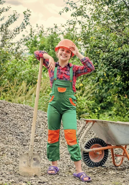 Vidám gyermekmunkás épület egyenruha és ásó és építési talicska, gyermekkor — Stock Fotó