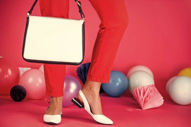 Renkli balonlarda çantalı zarif ayakkabılı kadın ayakları, moda aksesuarları.