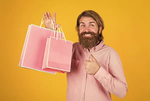 Regarde là-bas. Un accro au shopping. homme barbu prêt pour les vacances. vente et rabais. hipster avec barbe tenir sac présent. brutal hipster caucasien avec cadeau. mâle aller faire du shopping avec achat — Photo