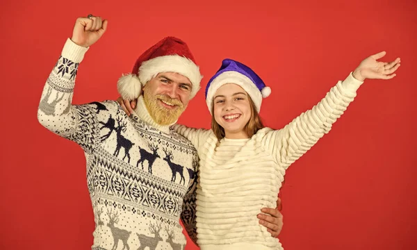 Χριστουγεννιάτικο πάρτι. γενειοφόρος μπαμπάς μικρό κορίτσι santa καπέλο. αστείο πλεκτό πουλόβερ. Πατέρας και κόρη γιορτάζουν τα Χριστούγεννα. Χριστουγεννιάτικο πάρτι μαζί. Λατρεύουν τις οικογενειακές διακοπές. Χειμερινά Χριστούγεννα. Η νέα χρονιά είναι εδώ. — Φωτογραφία Αρχείου