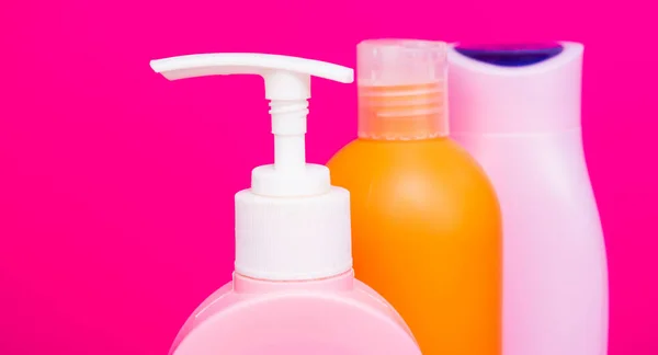 Läckagesäker. Närbild pump och flip cap flaskor. Kosmetiska flaskor rosa bakgrund. Förpackning av toalettartiklar — Stockfoto