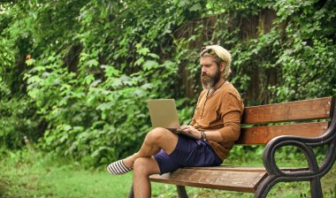 Çevik iş. Sakallı adam park doğasında bankta oturuyor. Çalış ve rahatla. İnternette çalışıyorum. Hippi parkta ilham kaynağı oldu. Temiz hava. Gezici internet. İstediğin yerde çalışabilirsin. İnternetten alışveriş
