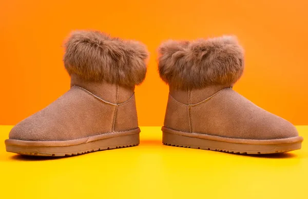 Par de botas ugg de invierno de moda sobre fondo naranja, moda —  Fotos de Stock