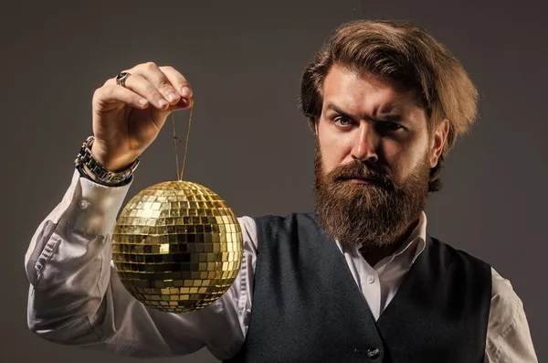 Взрослый мужчина с бородой держит золотой шар диско, концепция роскошной жизни — стоковое фото