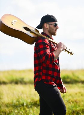 İlham perisi arıyorum. Yaz tatili. Hayalperest gezgin. Huzurlu bir ruh hali. Yürüyüş şarkısı. İlham arayan bir müzisyen. Doğayla bütünleşti. İlham verici bir doğa. Gitar çalan yakışıklı adam doğayı düşünüyor.