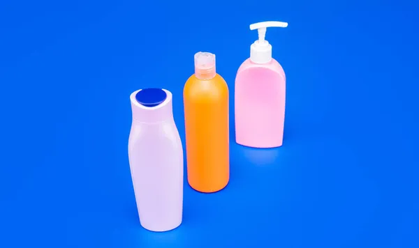Pojemniki do pakowania toalet wielokrotnego napełniania HDPE wielobarwne niebieskie tło przestrzeń do kopiowania, butelki — Zdjęcie stockowe