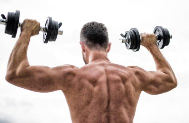 Dambıl arka görüşle egzersiz kaslı adam. Eylemler koçlardan daha yüksek sesle konuşur. Güçlü sırtı ve kolları olan sporcu. Spor ekipmanları. Vücut geliştirme sporu. Spor yaşam tarzı. Halter egzersiz salonu