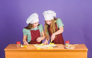 Çocuklar önlük ve şef şapkalar yemek. Aile tarifi. Aşçılık eğitimi. Anneler günü. Zencefilli kurabiye pişiriyor. Kız kardeşler zencefil hamuru yla eğleniyorlar. En iyisi ev yapımı kurabiye. Çocuklar birlikte kurabiye pişiriyor