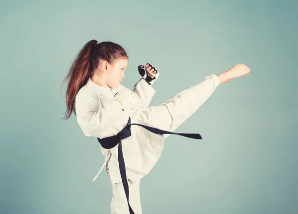 Karate gives feeling of confidence. Strong and confident kid. She is dangerous. Girl little child in white kimono with belt. Karate fighter ready to fight. Karate sport concept. Self defence skills — Stock Photo, Image