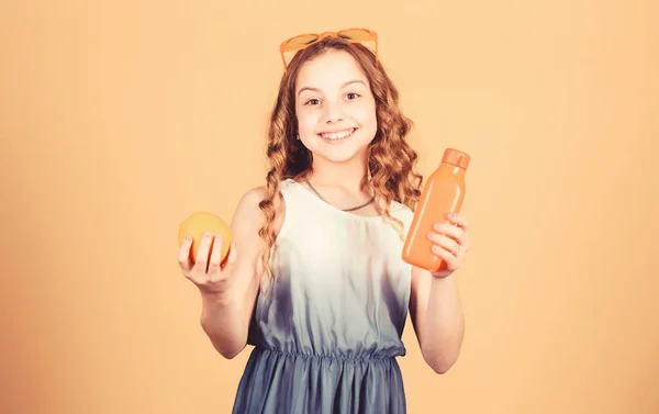 Mała dziewczynka w okularach mody. orzeźwiający sok witaminowy. Opieka zdrowotna. Dieta letnia witamina. Naturalne źródło witaminy. szczęśliwy dziewczyna pić świeży sok pomarańczowy. Wakacje. Ciesząc się nowy wielki dzień — Zdjęcie stockowe