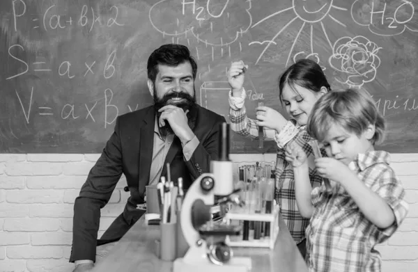 Πρώιμη ανάπτυξη των παιδιών. οπτικό μέσο μικροσκόπιο στην τάξη της επιστήμης. ευτυχισμένο παιδί δασκάλα. πίσω στο σχολείο. Μάθετε χρησιμοποιώντας το μικροσκόπιο στο μάθημα του σχολείου. Όπου τα μικρά πράγματα σημαίνουν πολλά — Φωτογραφία Αρχείου