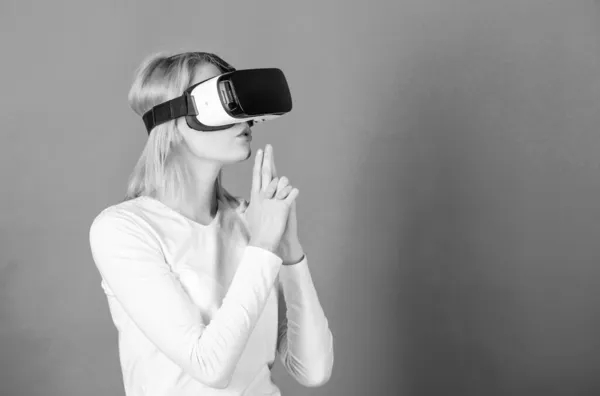 Egy nő izgatott 3D-s szemüveggel. Egy fiatal nő virtuális valóság fülhallgatót használ. Lenyűgöző fiatal nő megérintette a levegőt a VR élmény alatt. VR-kép. — Stock Fotó