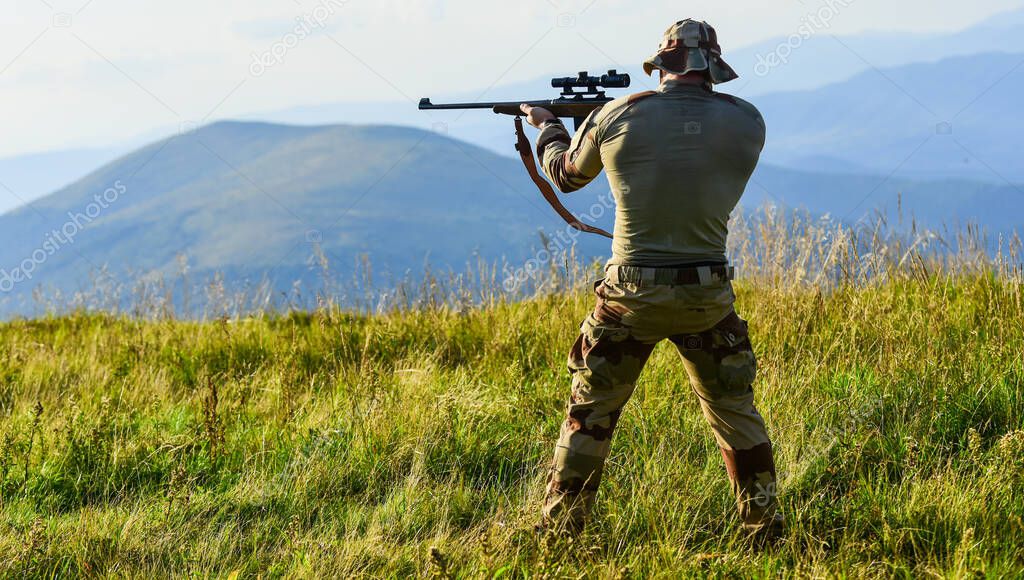 Nice shot. Army forces. Man military clothes with weapon. Brutal warrior. Rifle for hunting. Hunter hold rifle. Hunter mountains landscape background. Focus and concentration experienced hunter