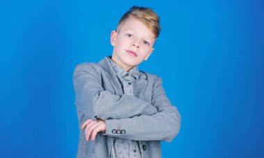 Ciddi genç adam. Mavi arka plan üzerinde küçük bir çocuk. Emin küçük çocuk. Silah tutmak yakışıklı çocuk geçti. Çok güzel okul öncesi çocuk veya öğrenci resmi aşınmaya