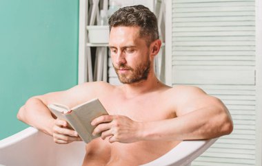 Tam bir rahatlama. Kişisel hijyen. Sinir sistemi banyo yarar. Rahatla konsepti. Adam kas gövde küvet dinlenmek ve kitap okuyun. Sıcak banyoda dinlenirken rahat adam kitap okuyor. Evde rahatlayın