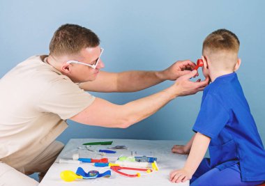 Hastane çalışanı. Tıbbi hizmet. Adam doktor küçük çocuk hasta muayene masa tıbbi araçları oturup. Sağlık. Çocuk doktoru kavramı. Dikkatli bir çocuk doktoru çocuğun sağlığını kontrol edin. Tıbbi muayene