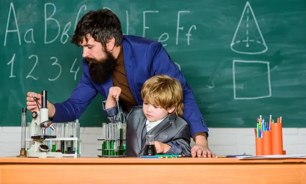 Lehrer mit kleinem Jungen. Schullaborausstattung. Student bei naturwissenschaftlichen Experimenten mit Mikroskop im Labor. Zurück zur Schule. Vater und Sohn in der Schule. mit dem Mikroskop im Labor. Leben im digitalen Zeitalter — Stockfoto