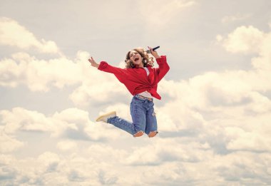 Genç ve güzel. Özgürlüğü hisset. Müzik benim hayatım. Çocuk mikrofonla şarkı söylüyor. aktif ve enerjik. Çocuk partide iyi eğlenceler. Mikrofonlu mutlu şarkıcı. Kız gökyüzünde şarkı söylüyor. vokal okulu konsepti