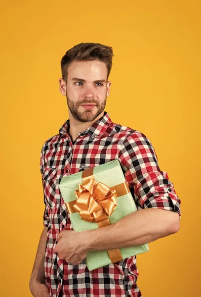 Чоловік з модним доглянутим волоссям і бородою тримає коробку, подарунок — стокове фото
