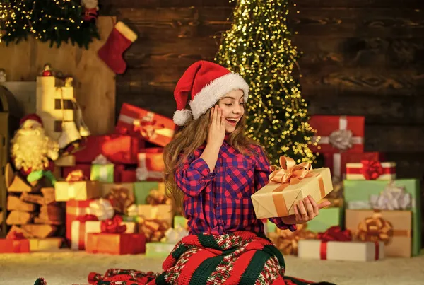 Zaskoczony. Piękny pokój urządzony z drzewa z prezentami pod nim. Scena sylwestrowa z drzewem i prezentami. Świętujemy przyjęcie świąteczne. Mała dziewczynka Boże Narodzenie zakupy online. dostawa prezenty świąteczne — Zdjęcie stockowe