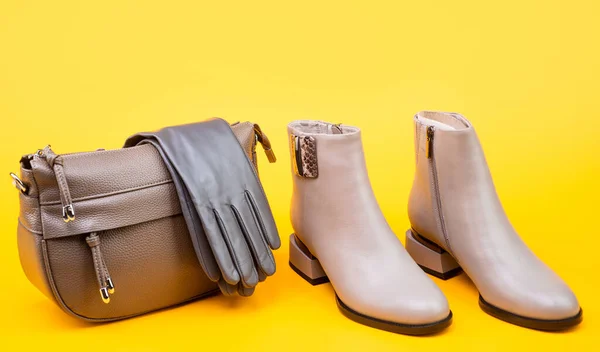 Leather beige boots gloves and bag on yellow background, fashion — Stock Photo, Image