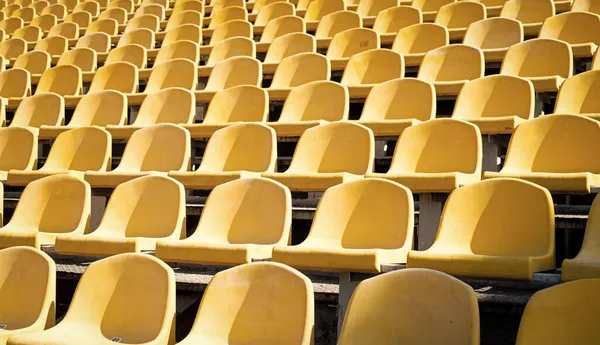 Yellow tribunes. seats of tribune on sport stadium. empty outdoor arena. concept of fans. chairs for audience. cultural environment concept. color and symmetry. empty seats. modern stadium — Stock Photo, Image