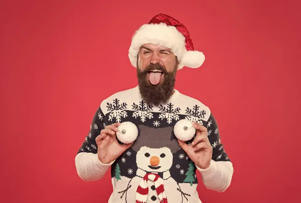 Tempo de compras de Natal. decoração de árvore. Um homem feliz de chapéu de Pai Natal. diversão festa de ano novo. celebrar as férias de inverno. Feliz Natal. Feliz Natal. homem de camisola segurar bolas de neve decorativas. Todos receberão um presente. — Fotografia de Stock