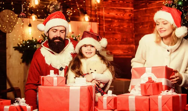 Recuerdos de Navidad. Momentos felices. Una chica en casa en Nochebuena. Adopción de niños. El chiquitín celebran un nuevo año con la pila de los regalos. Las tradiciones navideñas. Caridad y bondad. Para hacer el bien. Sentirse amado — Foto de Stock