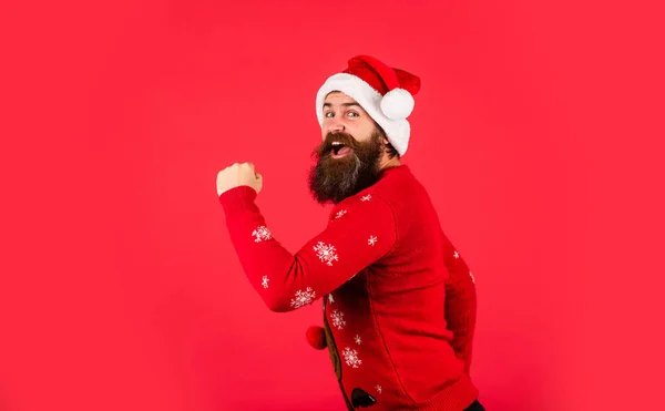 Vamos às compras. cara caucasiano feliz aguardar presente de ano novo. Vamos divertir-nos. Papai Noel hipster. Um homem bonito no Natal. brutal barbudo masculino vermelho fundo. festa homem em camisola de Natal — Fotografia de Stock