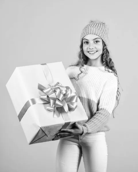 Dziękuję. Koncepcja świąt. Szczęśliwa mała uśmiechnięta dziewczynka z pudełkiem prezentów świątecznych. dziecko trzymać prezent pudełko żółte tło. Wesołych Świąt i Nowego Roku. Prezent świąteczny w dłoni — Zdjęcie stockowe
