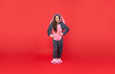 Mutlu çocuk yumuşak gece elbisesi giyer. Tam boy. Çocuk rahat bir uyku tulumu içinde poz veriyor. Tatlı rüyalar..