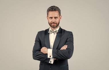 Etkinlik yöneticisinin kendine güveni ve şıklığı. Tüylü, olgun, tıraşsız bir adam. Smokinli yakışıklı iş adamı. Erkek moda papyonu. Estetik gelişim. lüks ve başarı