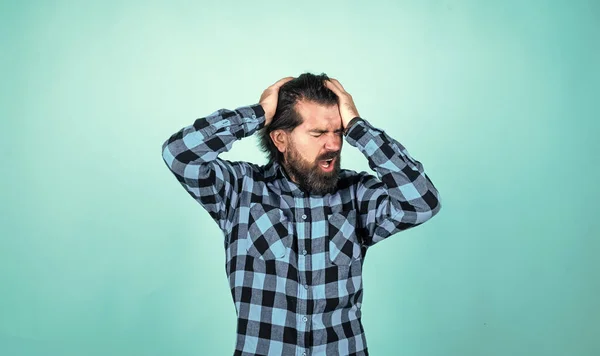 Expressing human emotions. suffering man in checkered shirt. man with headache on blue background. brutal bearded hipster feel pain. mature guy with moustache on face — Stock Photo, Image
