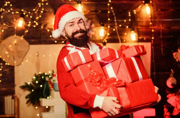 Санта Клаус хранит много подарков. Празднуйте с радостью. Отпразднуйте зимние праздники. Пусть ваш дом будет наполнен всеми радостями сезона. Мужчина бородатый Санта празднует Рождество с подарками. Новогодний праздник — стоковое фото