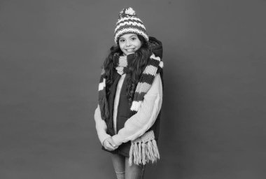 Mutlu yüzlü çocuk kışlık giysiler giyiyor ve tatillere, kış tatillerine hazırlanıyor.