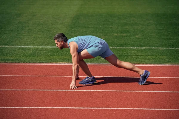 에너지. 근육질의 남자가 달리기 시작 합니다. 경기장에서 뛰고 있는 남자. 스포츠와 건강 한 생활 습관. 운동은 성 공적이다. 남자 운동 선수는 아침에 운동을 한다. 옥외 운동 선수. 건강 관리 — 스톡 사진