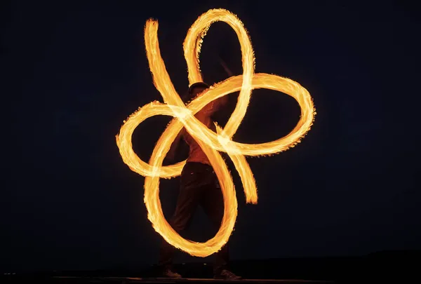 Artista de fuego individual realizar espirales infinitas girando pois llameante en el cielo oscuro en la noche al aire libre, llama —  Fotos de Stock